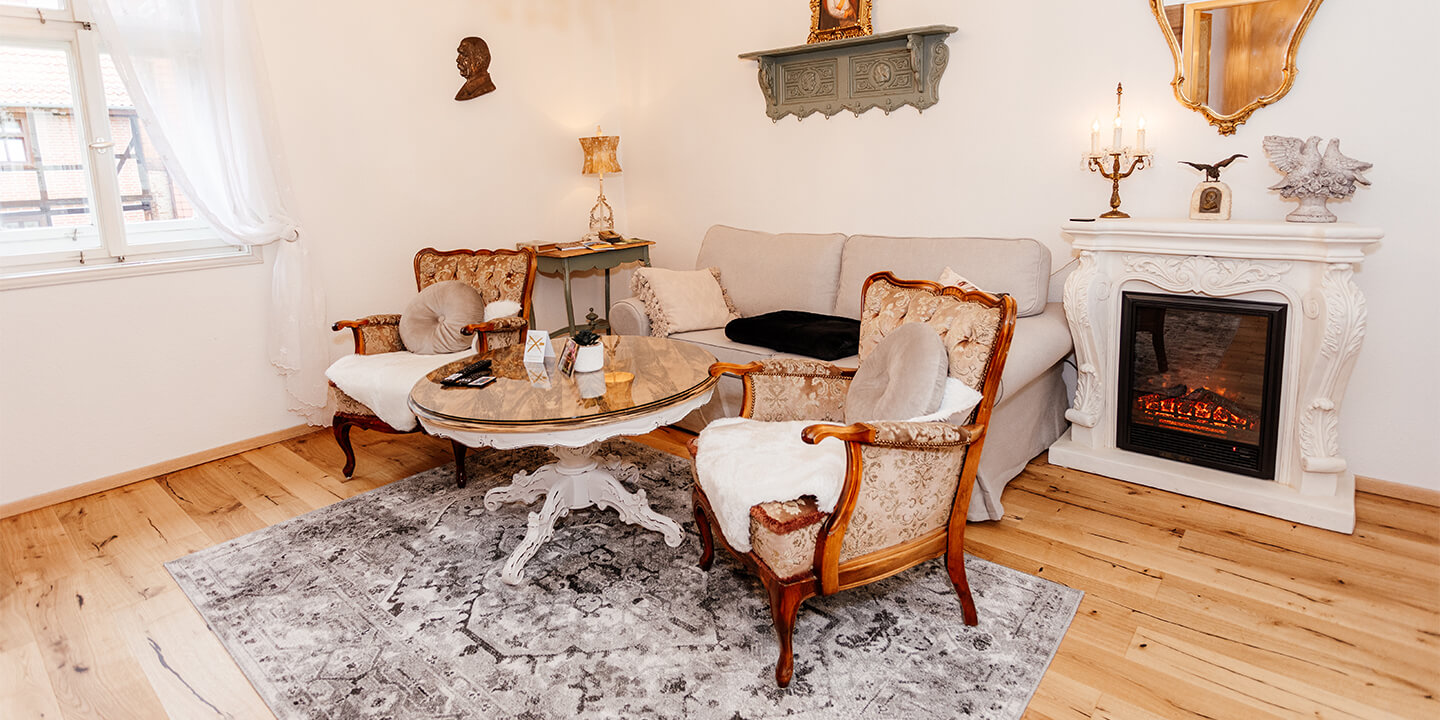 Wohnbereich der Bismarck-Suite mit antikem Sofa, Kamin und gemütlicher Atmosphäre